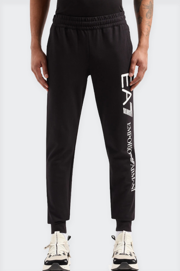 Men's tracksuit trousers made of 100% cotton. Slim fit, side pockets and one on the back, elastic waistband and contrasting logo