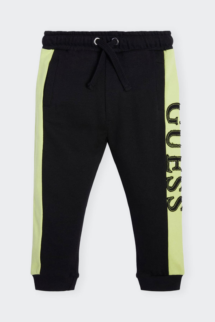 Black sweatpants for children made of cotton. Elastic waistband with drawstring and leg with elastic at bottom. Side logo on bot