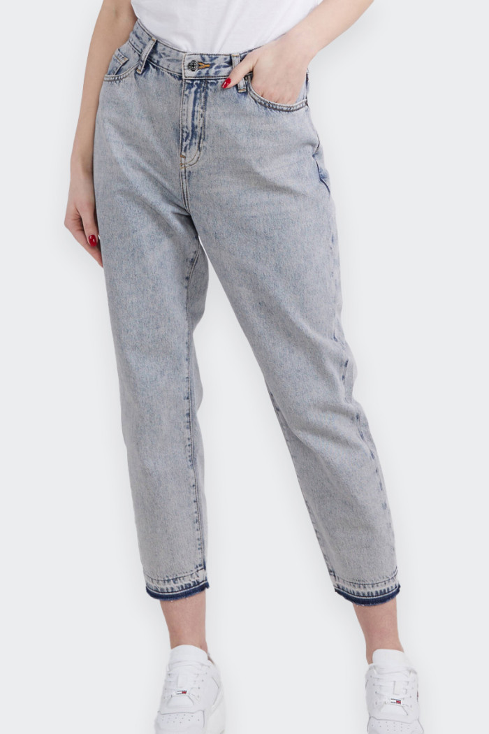 Women's 100% cotton jeans with cropped bottom and boyfriend fit characterized by five pockets. A model in which practicality com