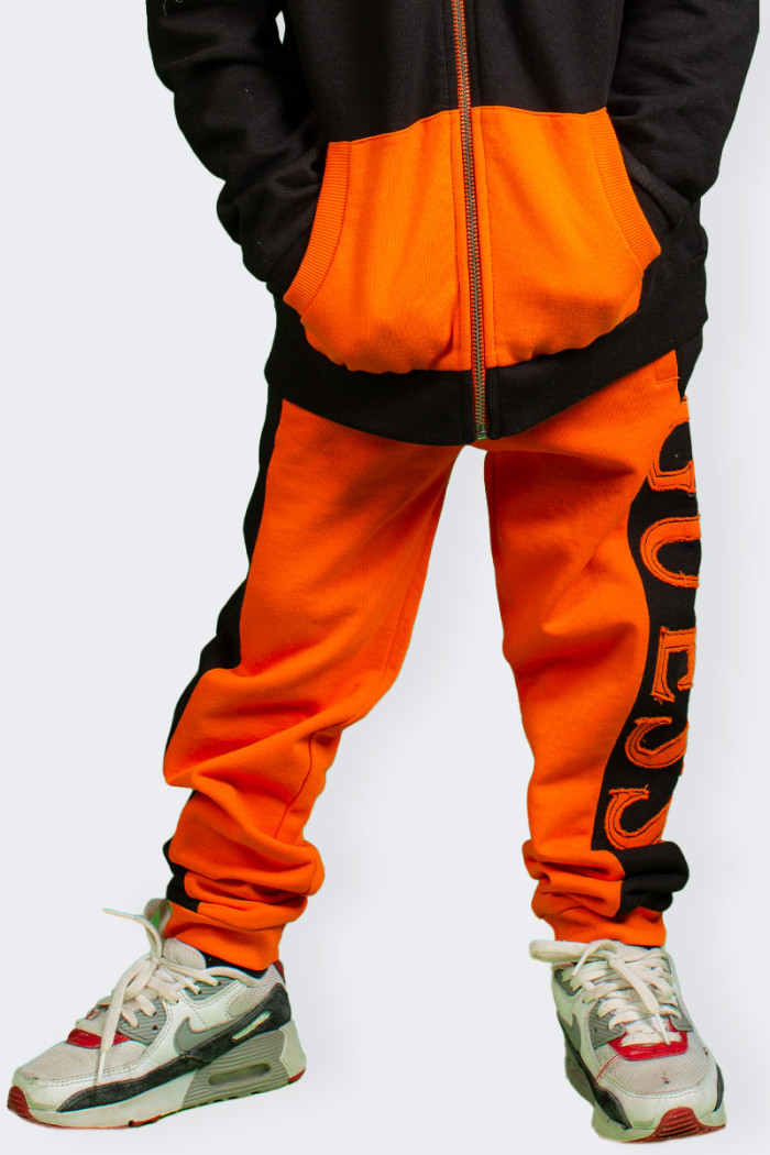 pantalone Guess di tuta arancione per bambino in cotone. Fascia elastica in vita con coulisse e gamba con elastico al fondo. Log