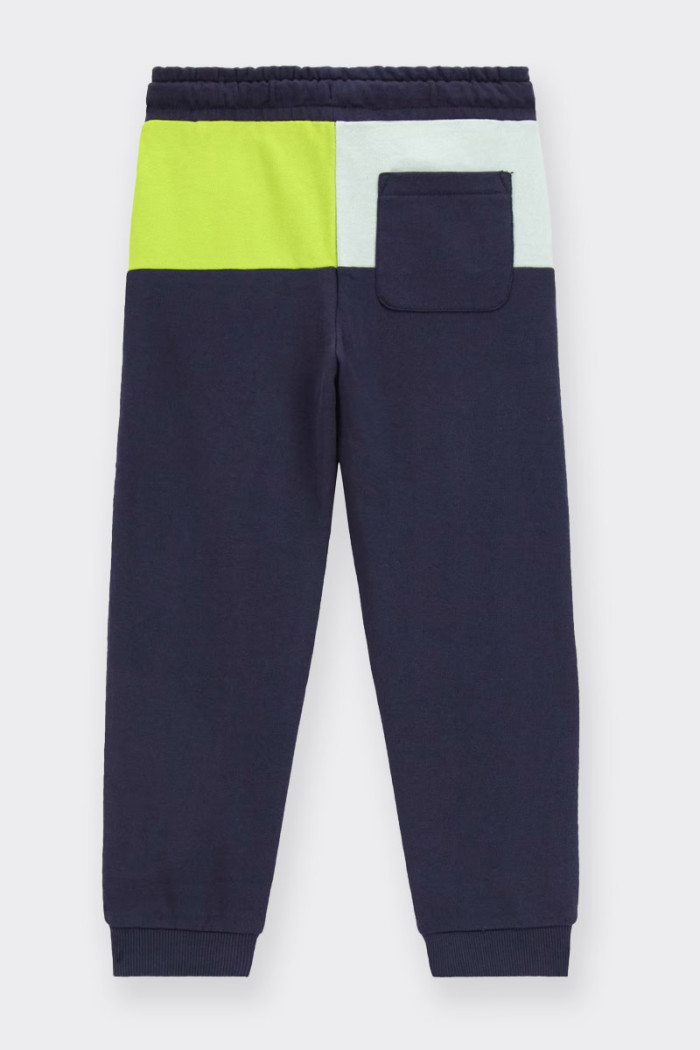 Child's tracksuit trousers made of 100% cotton with a medium waist and practical drawstring fastening. Back pocket and brand log